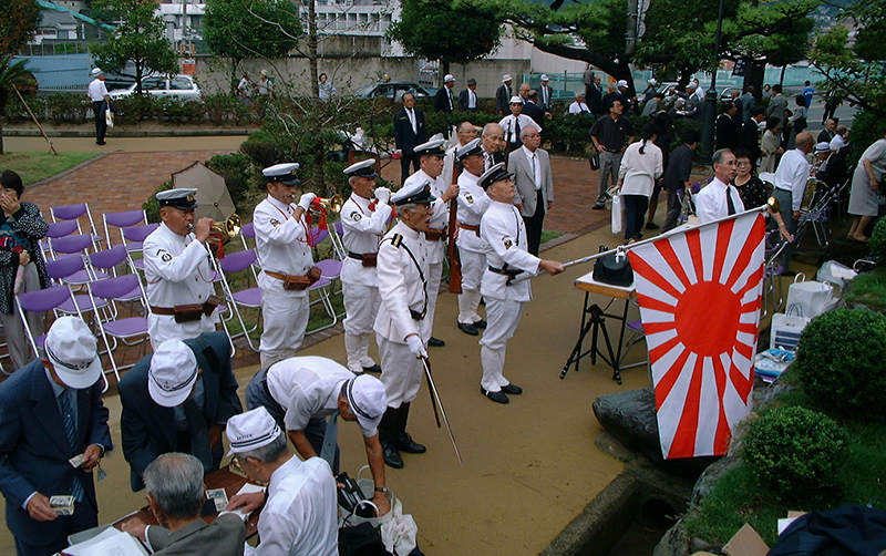 毎年9月23日、呉海軍墓地で合同追悼式が行われる。1998(平成10)年の時は、当時の服装で身を固めた人たちが各艦艇の慰霊碑ごとに「国の鎮め」を演奏した。写真は軍艦伊勢慰霊碑前。この様な情景は20年を経た今では見られない＝広島県呉市上長迫町で